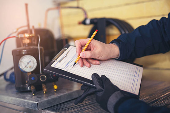 Texas Refrigeration Inc. technician documenting a refrigeration system inspection on a service call in the Fort Worth area