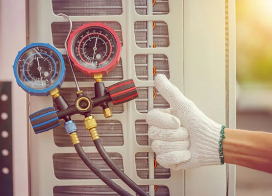 Technician checking refrigerant pressure gauges on an outdoor AC unit during a repair call near Fort Worth, TX
