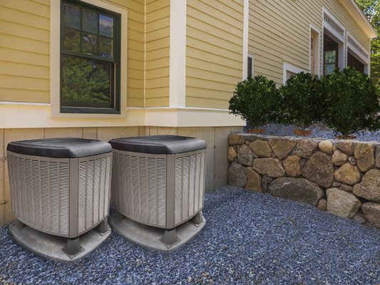 Two residential air conditioning units installed by Texas Refrigeration Inc. beside a home in the Fort Worth area